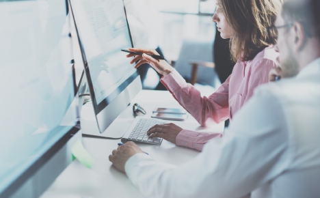 person looking and pointing at a computer screen